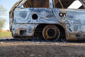Burned down car, abstract background, selective focus. The situation of protests in the world.