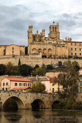 Fototapeta premium Vue depuis les rives de l'Orb sur la cathédrale Saint-Nazaire de Béziers au coucher du soleil (Occitanie, France)