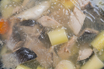 Salmon fish soup is cooked in boiling water. Culinary background with selective focus