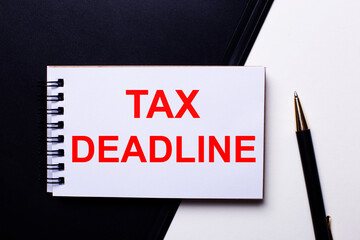 TAX DEADLINE written in red on a black and white background near the pen