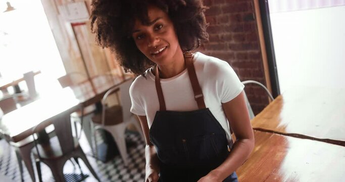 Waitress holding digital tablet smiling looking at camera in restaurant