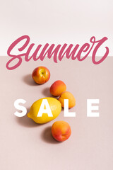 fruit composition with lemon and apricots near summer sale lettering on beige and white