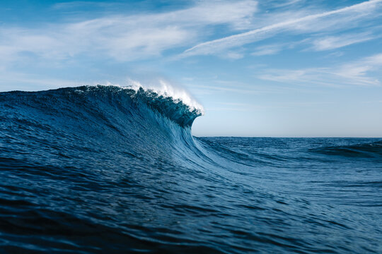 Powerful blue breaking ocean waves with white foam