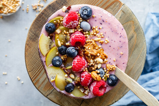 Top view of nutritious breakfast bowl with berries and yogurt served on table in morning
