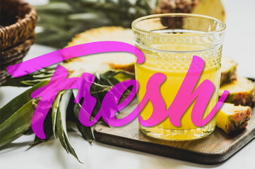selective focus of pineapple juice in glass near delicious fruit on cutting board and fresh lettering on white