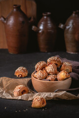 Small meat pies with sesame on dark background