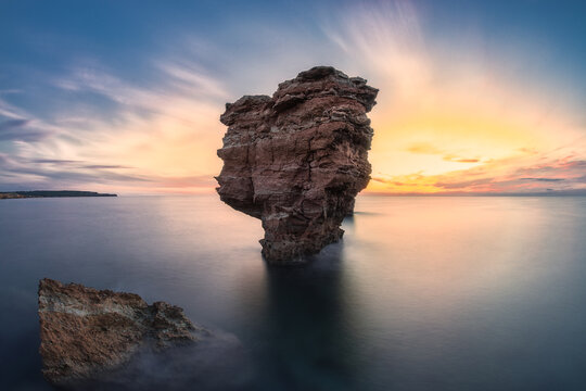 big rock on the sea at sunset