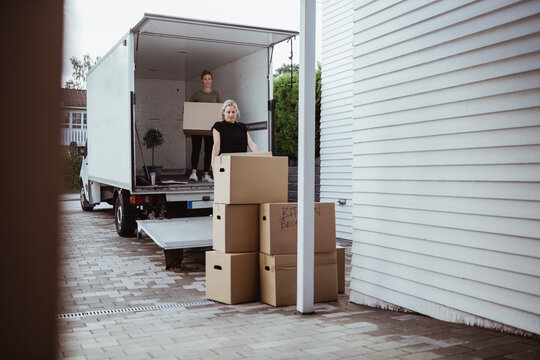 Female friends unloading boxes from van