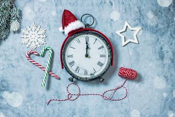 Vintage New Year's clock midnight next to New Year's decor, sweets, cones. Christmas clock background. Top view, flat lay