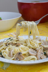 Detalle de un tenedor cogiendo pasta de un plato
