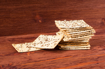 Stack of crispy wheat cakes with sesame seeds, flax and sunflower on a red wooden background. vegetarian food, eco food concepts