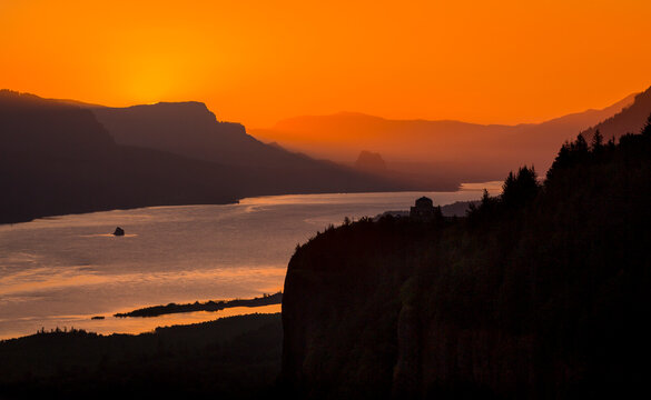 Scenic view of Columbia River flowing amidst mountains during sunrise