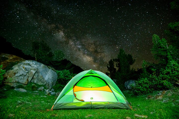 Scenic view of green tent under milky way in forest