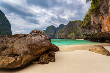 Scenic view of beach and mountains against cloudy sky