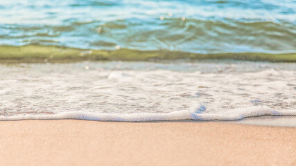 the waves of the sea on the sandy beach on a sunny day