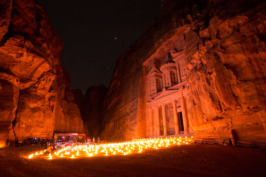 Scenic view of illuminated candles outside Al Khazneh temple at night - Powered by Adobe