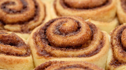 Freshly baked cinnamon rolls or Cinnabon close up, top view