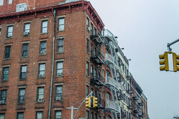 Manhattan Soho Building with Fire Escape Ladders on a Snowy Day of Winter. Classic Yellow Traffic...