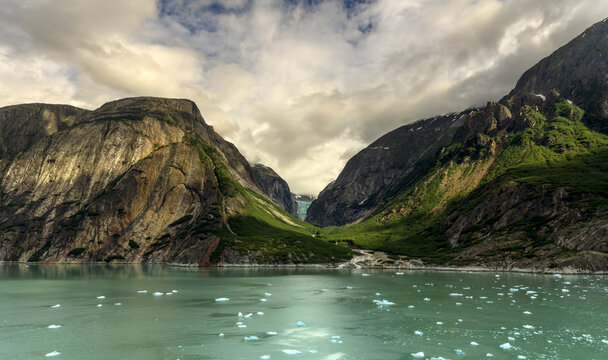 Scenic view of Tracy Arm fjord and mountain against cloudy sky