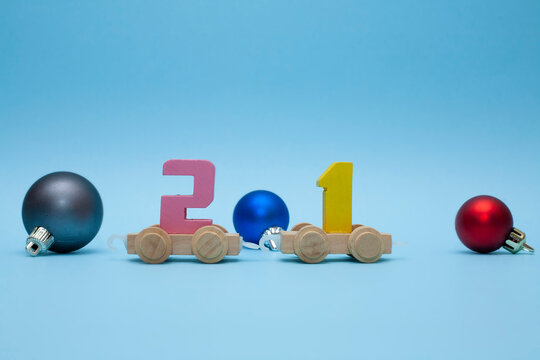 The children's train carries the number 21. The train on a blue background. Christmas decorations around the locomotive. Coming 2021