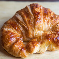 a croissant on a wooden board.