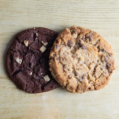 cookie with pieces of black and white chocolate on a wooden table.