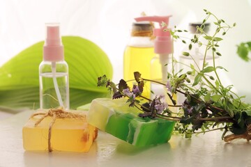 Soap, herbs, spray and bottles with aromatic oil on a wooden windowsill, natural homemade cosmetics, healthy lifestyle