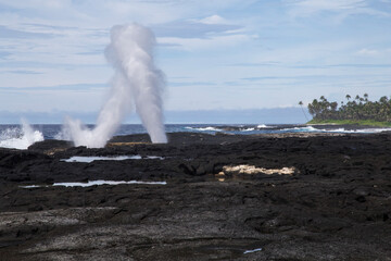 Famous Samoan blowholes at volcanic shore coast, under blue sky