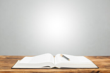 Open Bible book and pen on a wooden table.