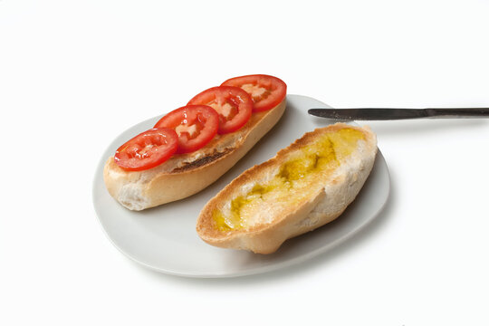 White Toasted Bread Drizzled With Olive Oil And Tomato Slices On A White Plate,isolated On A White Background.