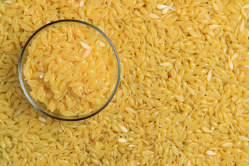 Background texture of yellow depilatory wax. Depilatory wax in a glass bowl. Depilation wax granules. Epilation, depilation, unwanted hair removal. Top view. Place for text.