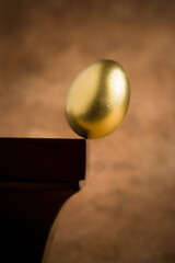 Golden egg balance on shelf.