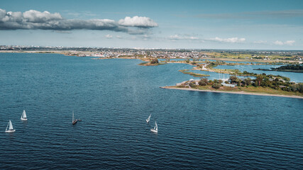 White yachts and a boat sail on dark sea water in the Kaliningrad Bay