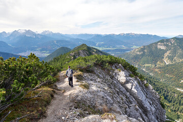 Hiker walking on a trail in the alpine mountains
