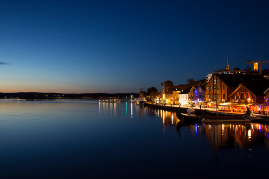 Amazing night shot of city harbour with viking ship, port with r