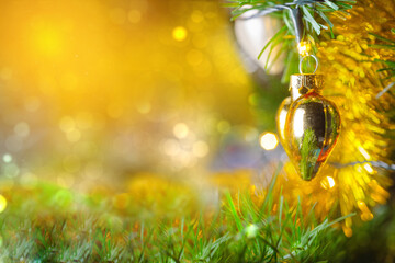 New Year's toy on a branch of a Christmas tree. Glossy Christmas toy in the shape of a heart...