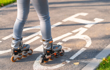 Active leisure. A sportive girl is rollerblading in an autumn park
