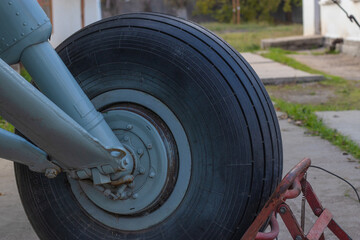 Front wheel of an aircraft, standing on the ground. Wheel rests on a special stop so that plane does not roll away from place