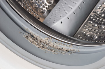 Dirty moldy washing machine sealing rubber and drum close up. Mold, dirt and limescale in washing machine. Home appliances periodic maintenance.