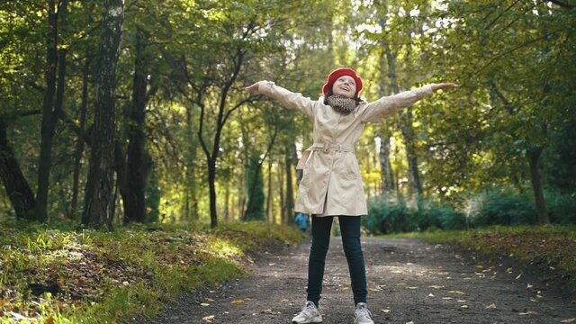 stylish girl rejoices in happiness, imagines that she is a free bird in nature. person walking in the park