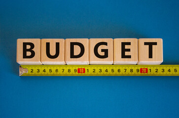 Budget word on cubes arranged behind the ruler on beautiful blue background. Business concept, copy space.