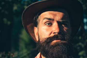 Closeup portrait of young handsome man. Guy with hat and serious face.