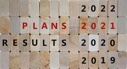 Business concept of planning 2021. Wooden blocks with the inscription 'result 2020, plans 2021'. 2019, 2022 numbers. Beautiful wooden background, copy space.