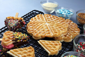 Belgium waffles with chocolate sauce. popsicles with chocolate and wafer on blue background