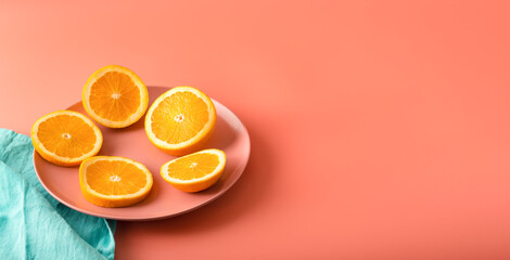 Slices of fresh juicy orange lie on pink plate. Citrus fruit is a symbol of the new year and Christmas. Copy space