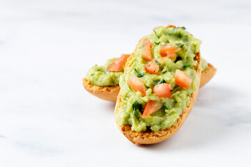 Guacamole toasts with tomato and parsley