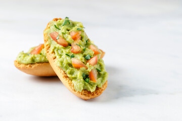 Guacamole toasts with tomato and parsley