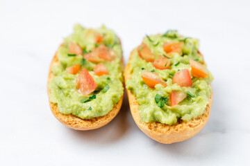 Guacamole toasts with tomato and parsley