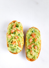 Guacamole toasts with tomato and parsley