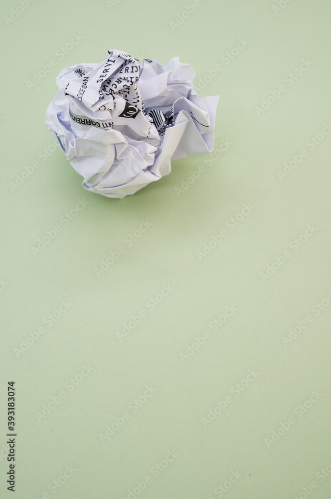 Sticker High angle shot of a wrapped paper ball isolated on a green background